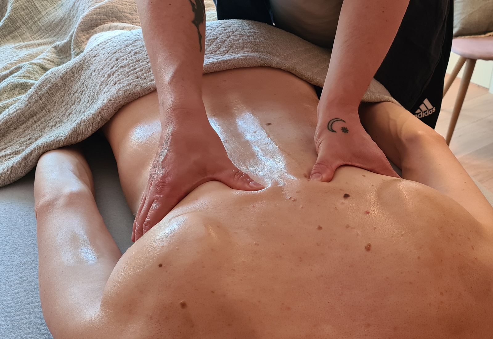 Massage af en klient på briksen i klinikken i Svendborg